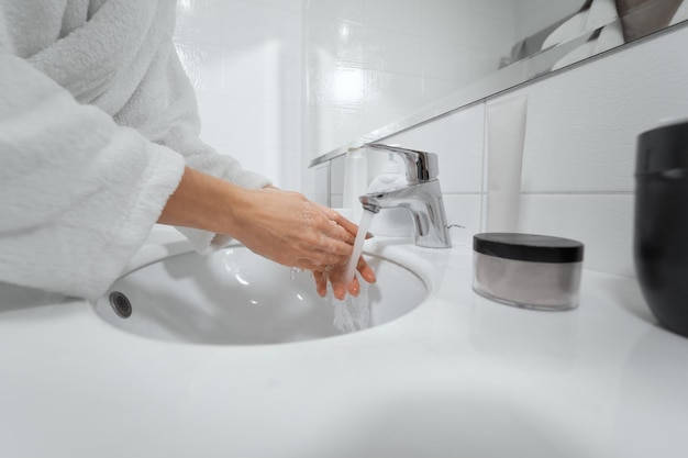 Washing hands in white bathroom