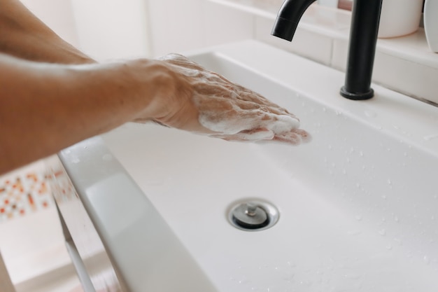 Washing hands with foam in the toilet concept of cleaning and protection