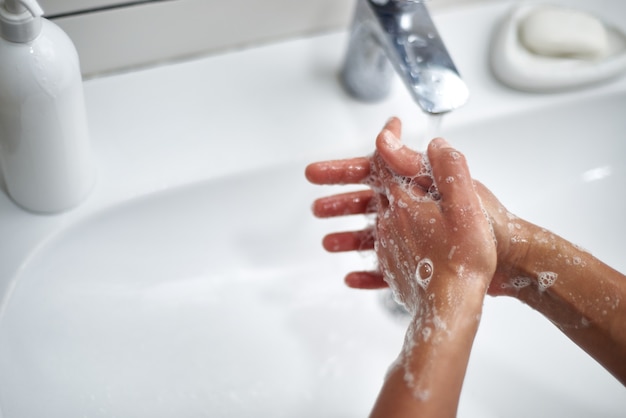 washing hands with soap between fingers