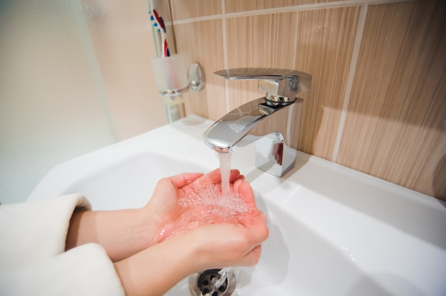 Washing of hands with soap under running water