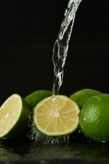 Washing lime with a stream of water, pouring water from the tap on the vegetables