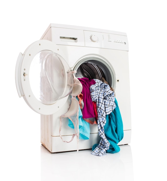 Washing machine with clean linen on a white background