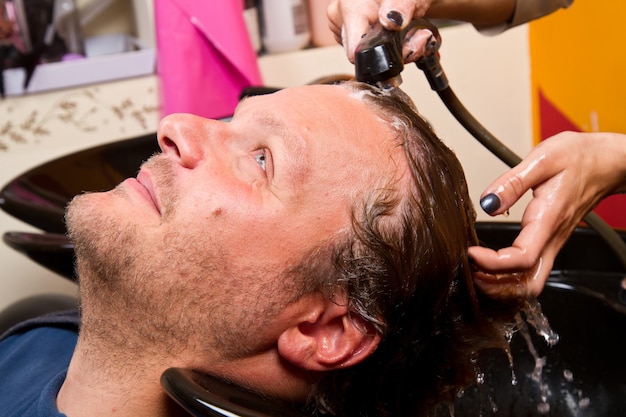 Washing man hair in beauty parlour hairdressing salon