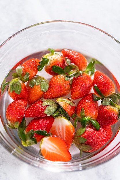 Washing organic strawberries in a bowl with water.