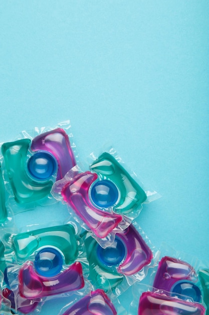 Washing powder in capsules on a blue background Vertical photo