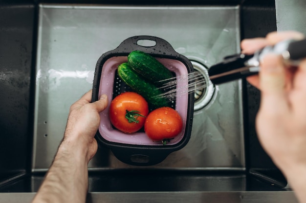 Washing vegetables in the kitchen Cucumbers Tomatoes