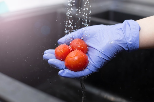 タップレッドトマトの下で野菜を洗う