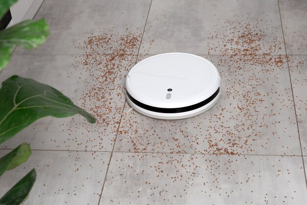 Washing White robot vacuum cleaner device cleaning floor from crumbs groats at home on utonite tiles in the kitchen.