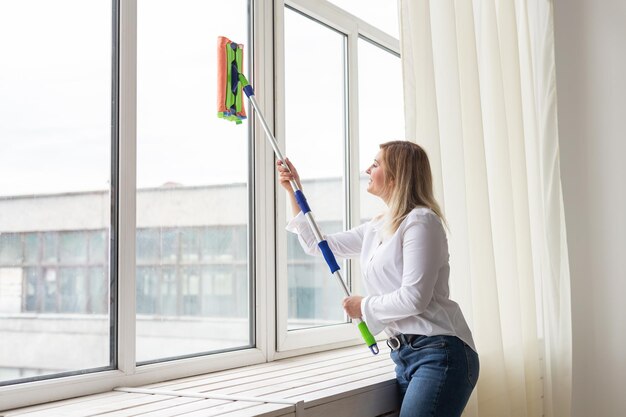 Washing window with special mop and cleaning services housework and housewife concept