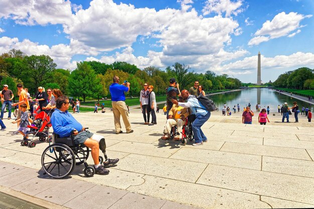 Washington Dc, Verenigde Staten - 2 mei 2015: Oorlogsveteraan en zijn bewaker van eervlucht bij Lincoln Memorial Reflecting Pool. Washington Monument op de achtergrond.