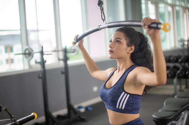 Wasit up image of a fit young African American woman working out with hand weights in a fitness gym