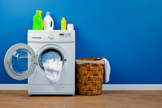 Wasmachine met wasserij op blauwe muurachtergrond