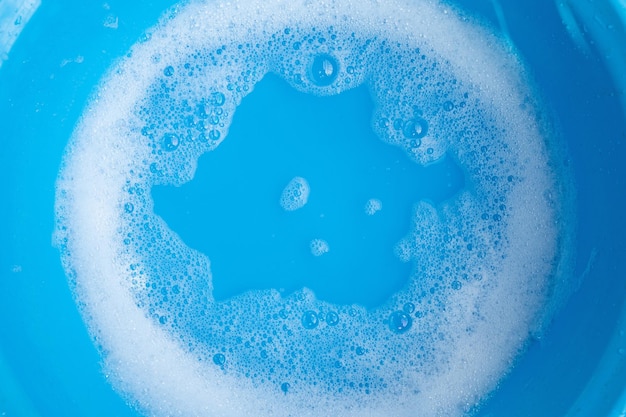 Wasmiddelschuimbel in blauwe bak