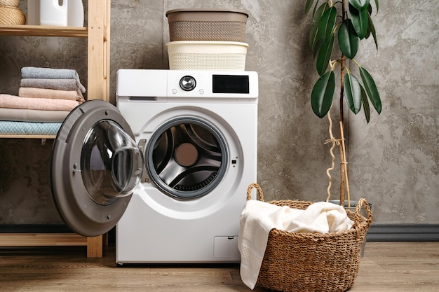 Wasruimte interieur met wasmachine in de buurt van grijze grunge muur