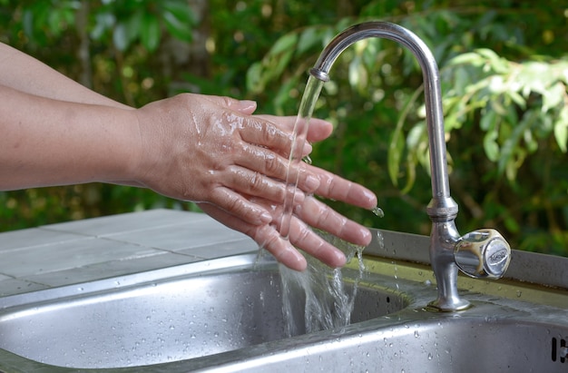 Wassen van handen onder stromend water.