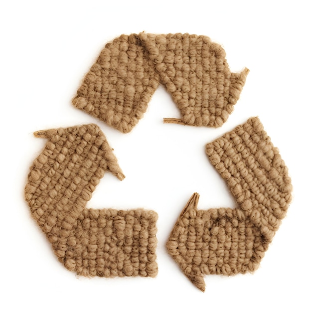 Waste recycling symbol made from brown textile material on white background