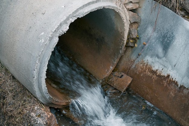 Foto le acque reflue scorrono da un tubo nel fiume affrontare l'inquinamento gestire le acque reflue e il fiume