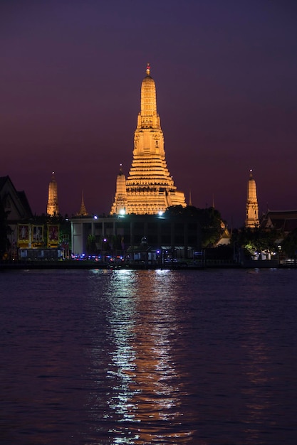 The wat arun is lit up at night.