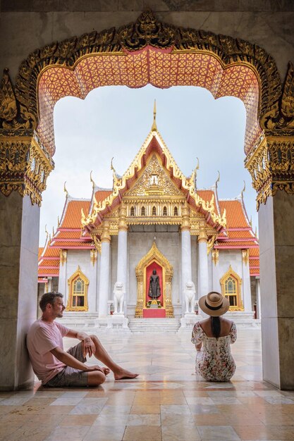 Photo wat benchamabophit temple in bangkok asian woman with hat and european men visiting a temple