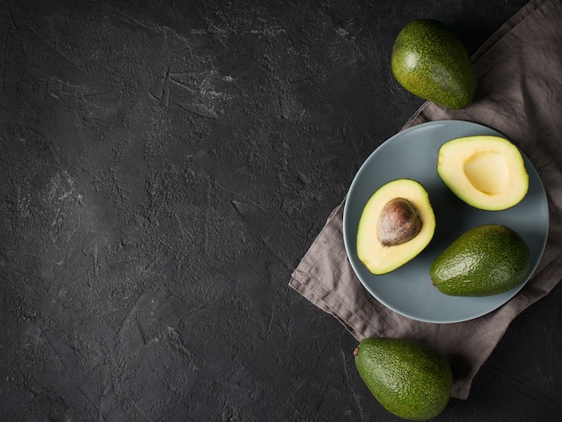 Wat fruit van avocado heel en half op bord over donkere achtergrond