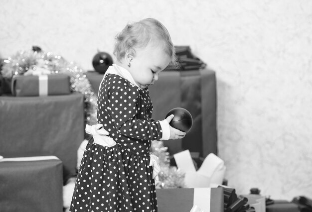 Wat te doen met peuters met kerst Cadeaus voor kind eerste kerst Klein babymeisje spelen in de buurt van stapel geschenkdozen Vakantie met het gezin Vier eerste kerst Kerstcadeaus voor peuter