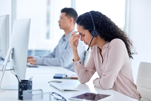 Wat zo moeilijk te begrijpen is shot van een jonge callcentermedewerker die bij haar collega zit en zich gestrest voelt terwijl ze haar computer gebruikt