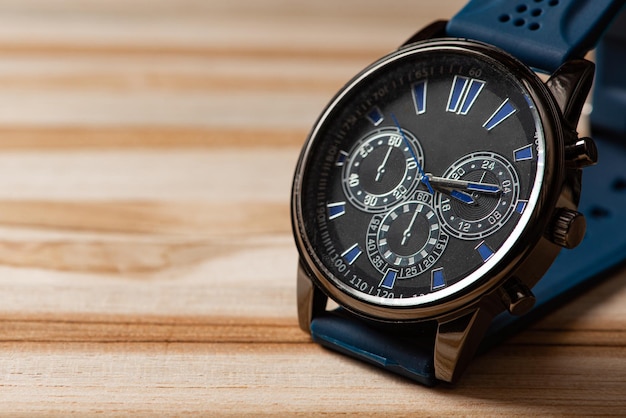 Watch, beautiful modern wristwatch positioned on a rustic wooden surface, selective focus.