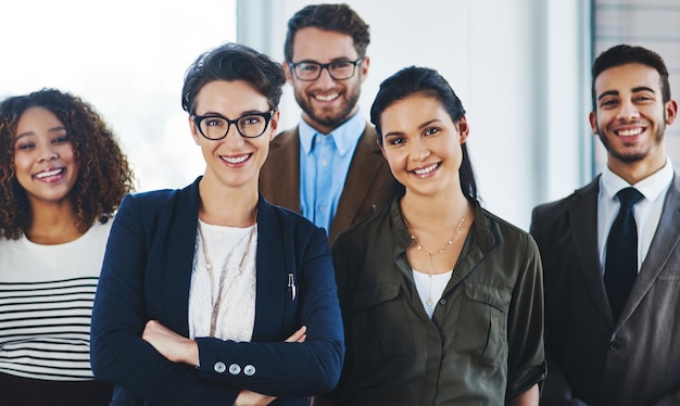 Guardaci salire al livello successivo ritratto di un team eterogeneo di professionisti che stanno insieme in un ufficio