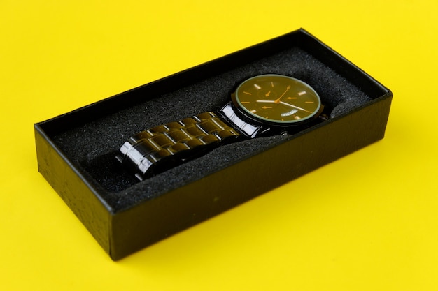 Watch, with black cardboard isolated on yellow background