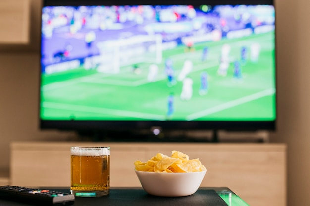 Foto guardando il concetto di calcio con birra e patatine