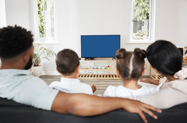 Watching tv or streaming a subscription service with green screen and chromakey together as a family at home Rearview of mother father and children getting ready to watch a movie or series