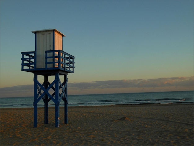 Foto torre di avvistamento al tramonto sulla riva della spiaggia