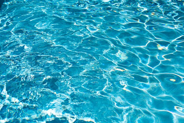 Water background blue water ripples and highlights texture of water surface and tiled bottom