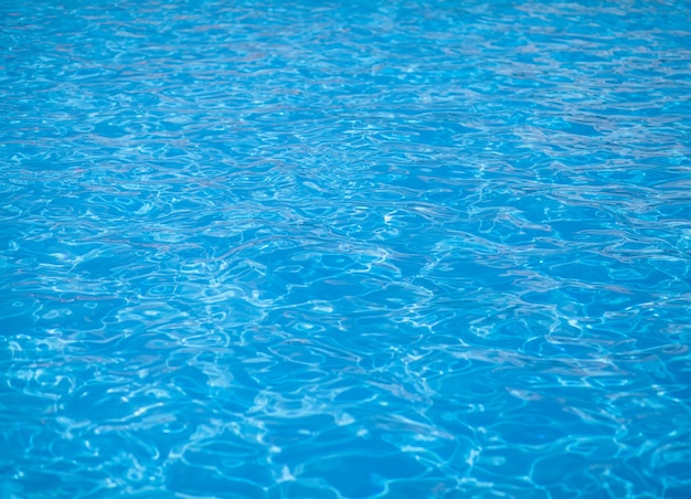 Water background, ripple and flow with waves. Summer blue swiming pool pattern. Sea, ocean surface. Overhead top view with place for text.