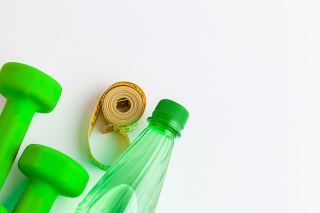 Water bottle and fitness equipment isolated on white