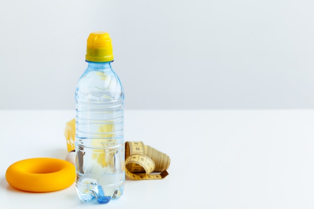 Water bottle and fitness equipment isolated on white