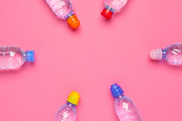 Water bottle flat lay top view on color paper background