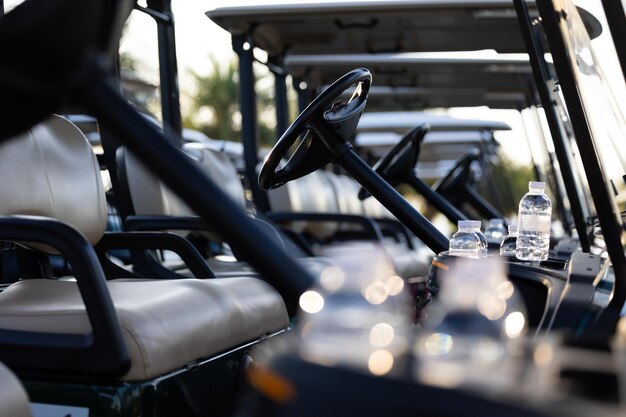 Photo water bottle in golf carts for golf player on golf course golf course carts cars at luxury golf club sport venue in neat line row