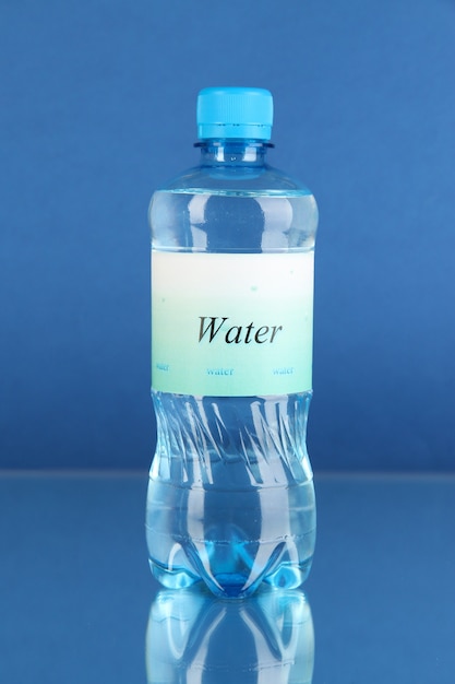 Foto bottiglia d'acqua con etichetta su sfondo blu