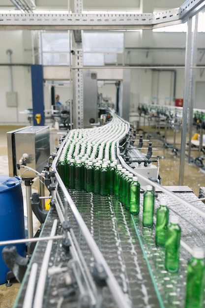 Water bottling line for processing and bottling pure mineral\
water into small green glass bottles. selective focus.