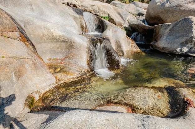 Water dat over rotsen in watervalcascade stroomt in een bos