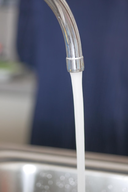 Water dripping from faucet tap at kitchen Closeup