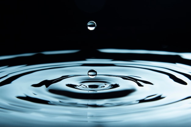 Photo water drop about to create ripple effect