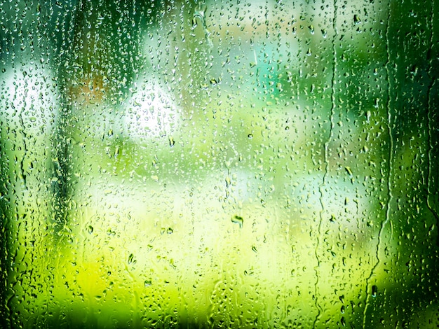 Water drop from raining on glass .