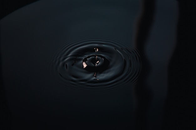 Water drop making waves in liquid surface