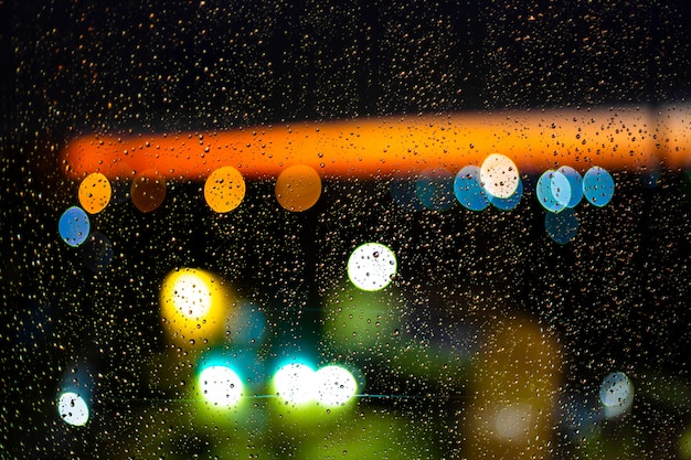 Water drop at windows and bokeh of city in sunset