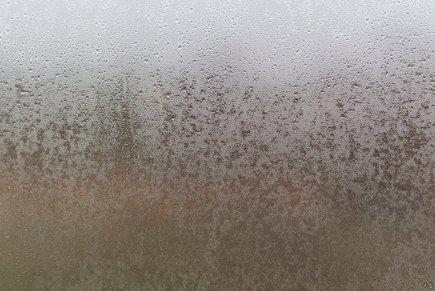 Water droplets condensation background of dew on glass, humidity and foggy blank. Outside, bad weather, rain