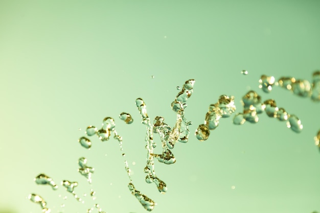 Water droplets frozen in the air with splashes and chain bubbles on a green isolated background in nature Clear and transparent liquid symbolizing health and nature