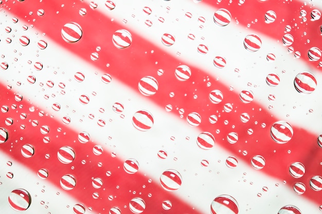 Water droplets on glass and cotton colorful backdrop