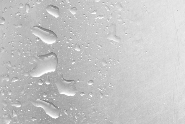 Капли воды на текстурированном сером фоне Стеклянный фон, покрытый каплями воды, демонстрирующий пузырьки в воде
